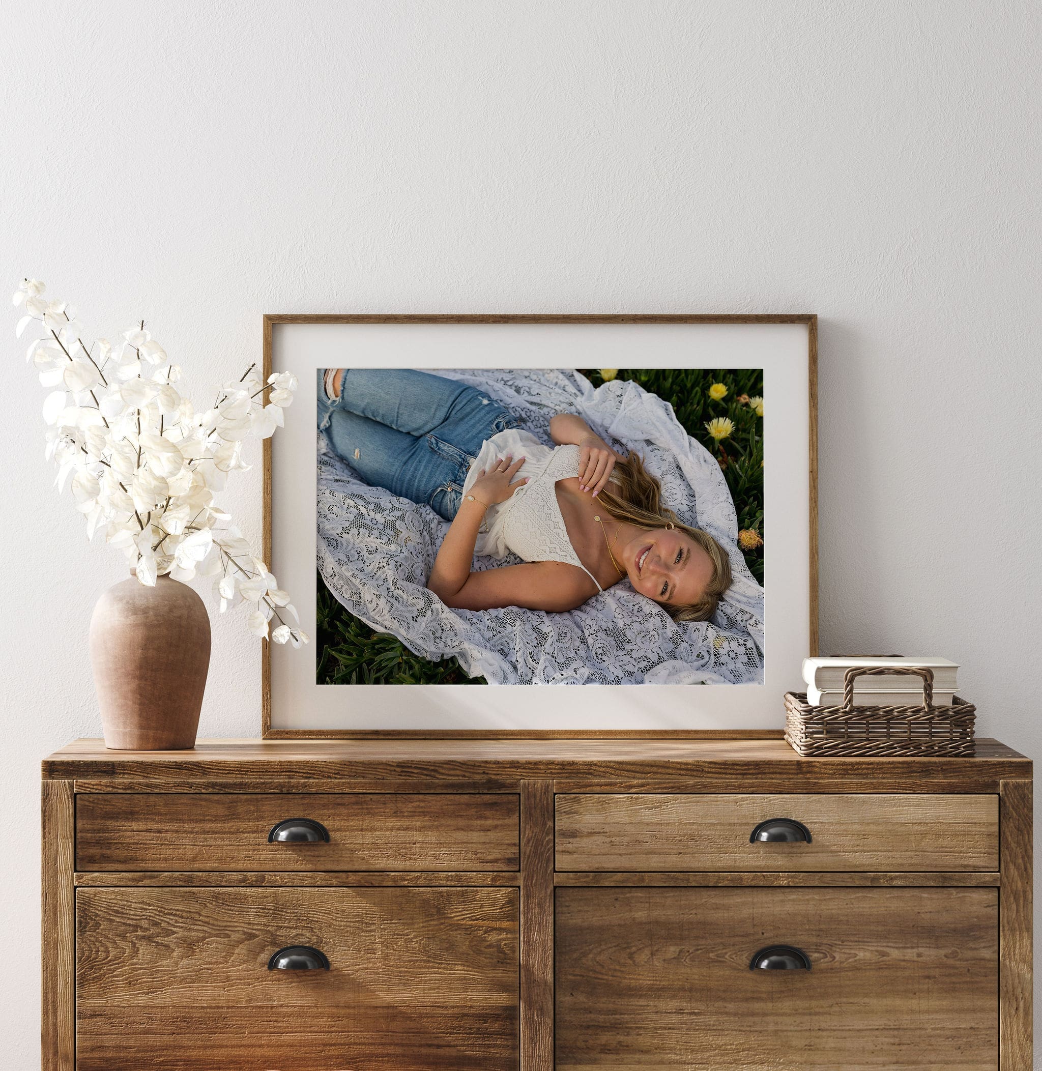 Details of a high school senior portrait on a dresser in a modern bedroom