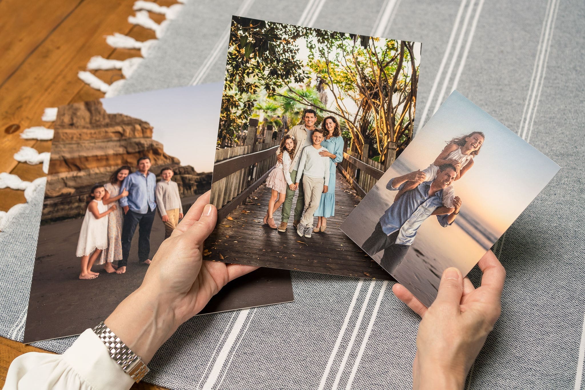 Details image of a woman admiring printed family portrait prints at a table