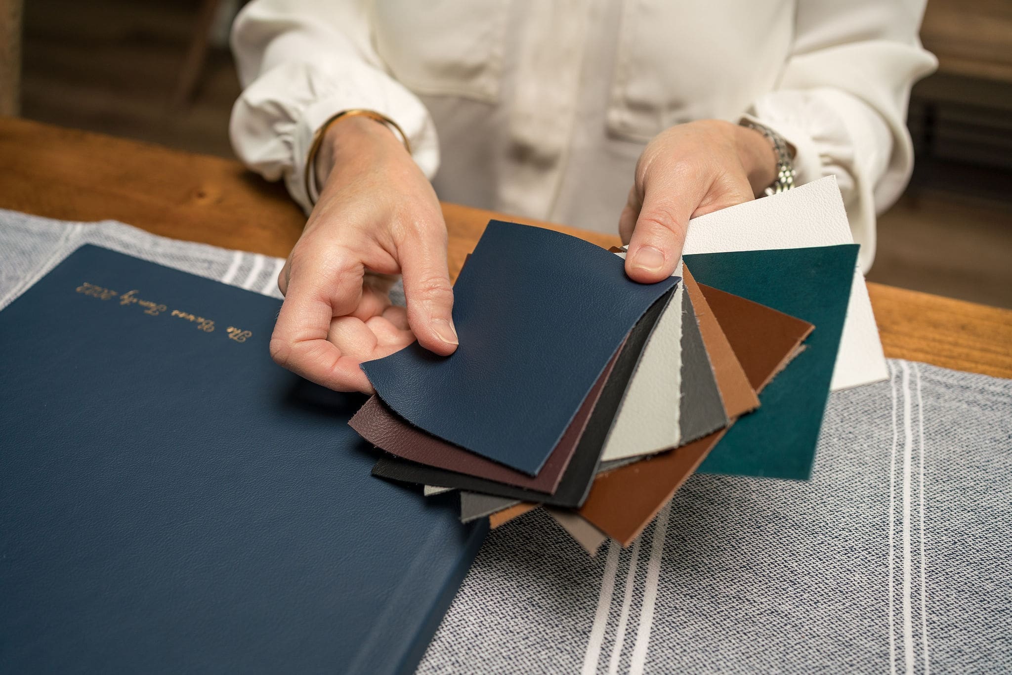 Details of album cover swatches fanned out by a woman's hands