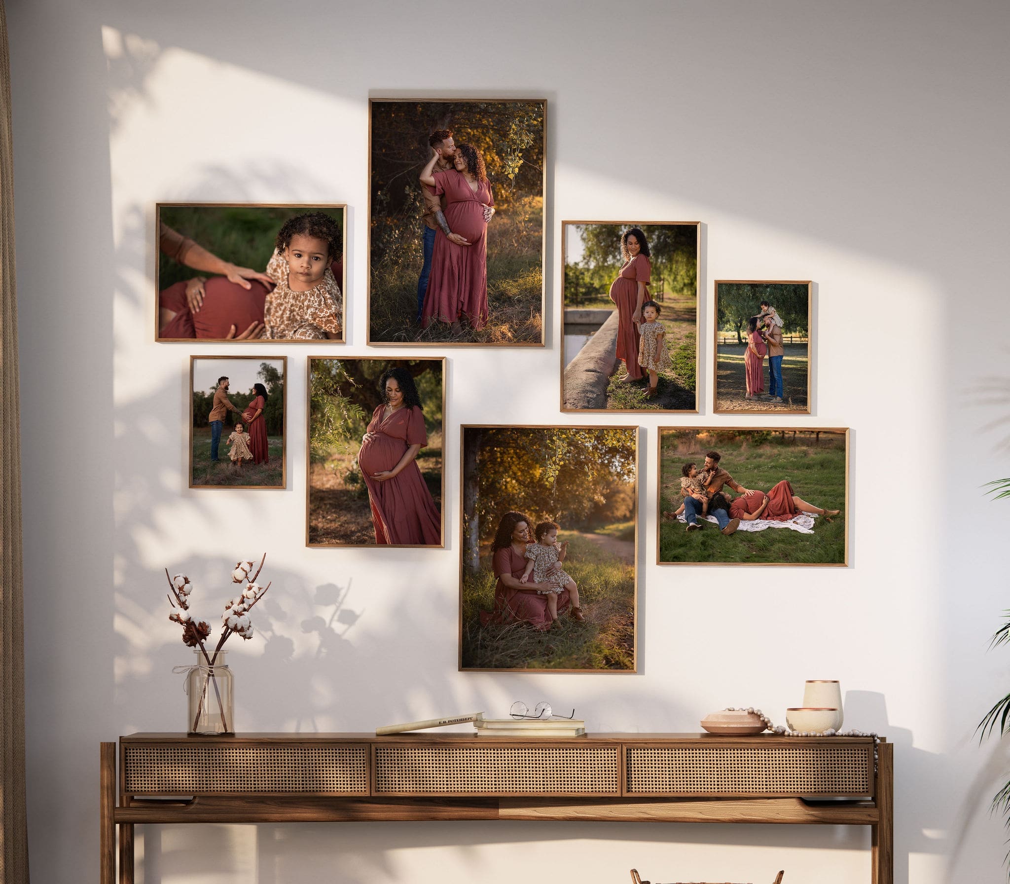 Fine art family and maternity portraits hang on a wall over a table in a home